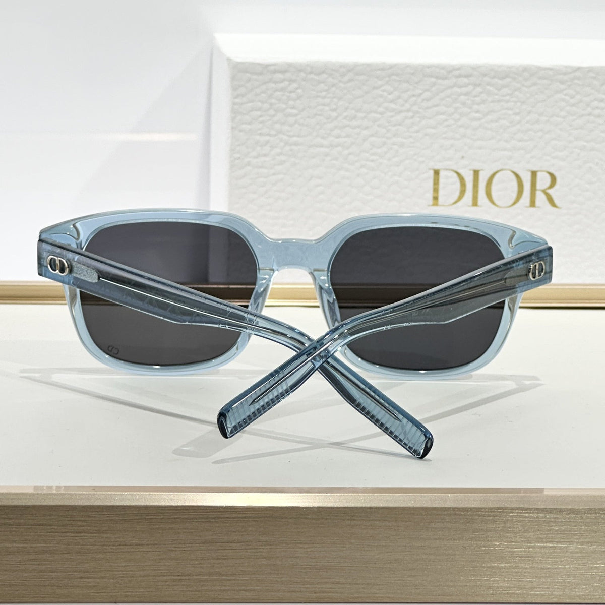D**R Square Sunglasses | Ice Blue Transparent Frame, Dark Grey Lenses & Black CD Logo Hinge