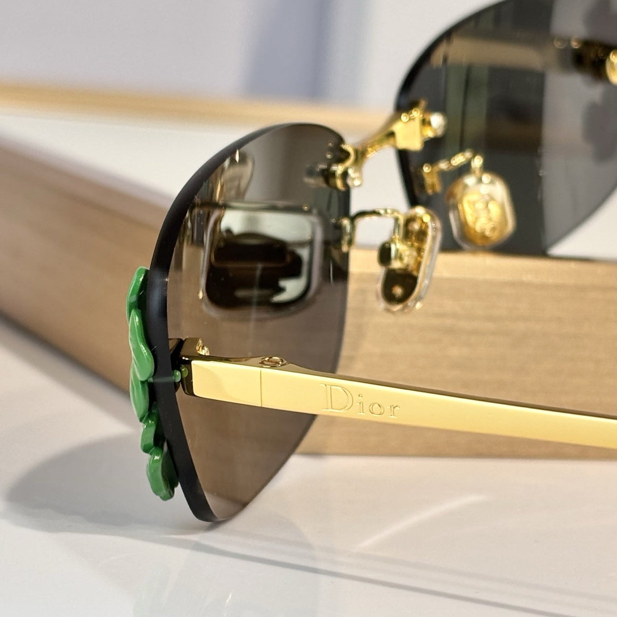 D**R Slim Rimless Rectangular Sunglasses with Dark Green Solid Lenses, Gold Metal Temples & Emerald Green Flower Cluster Embellishment