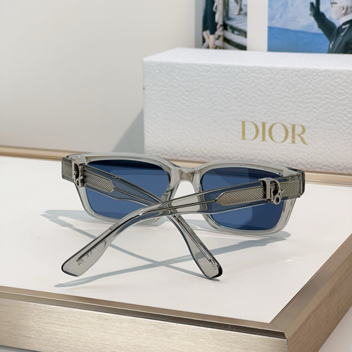D**R Thick Square Sunglasses with Crystal Grey Transparent Frame, Navy Blue Lenses & Engraved CD Temple Hardware